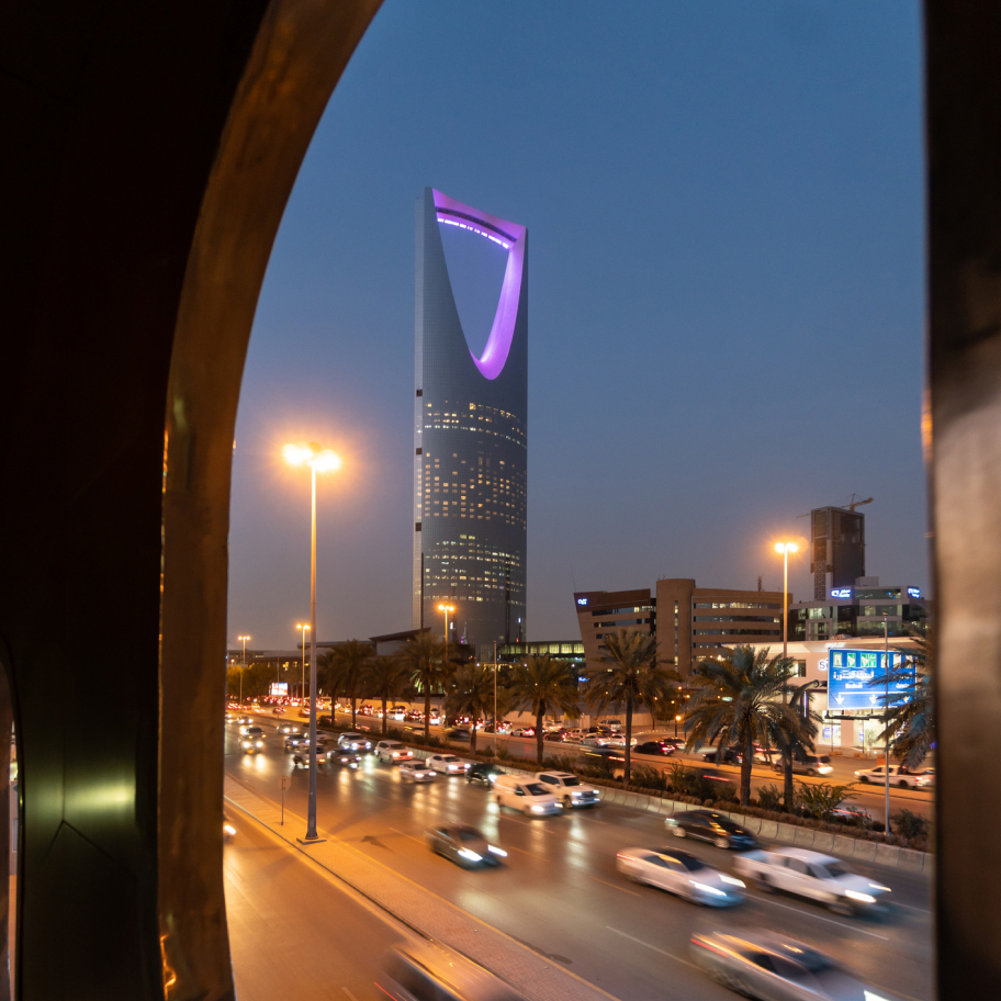 منظر ليلي لمركز المملكة في الرياض، المملكة العربية السعودية، مُؤطّر بإطار نافذة.