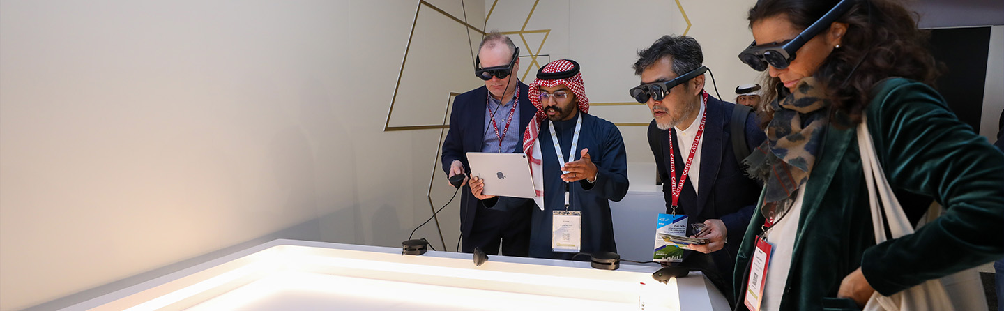 People using augmented reality glasses to interact with a digital display at a technology exhibition